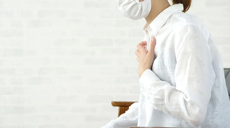 胸を抑える女性