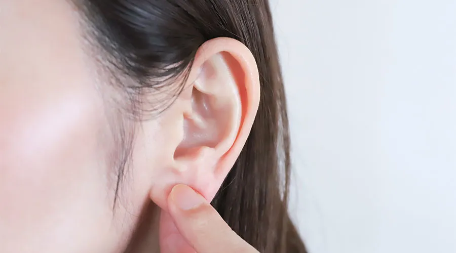 耳たぶをつまむ女性
