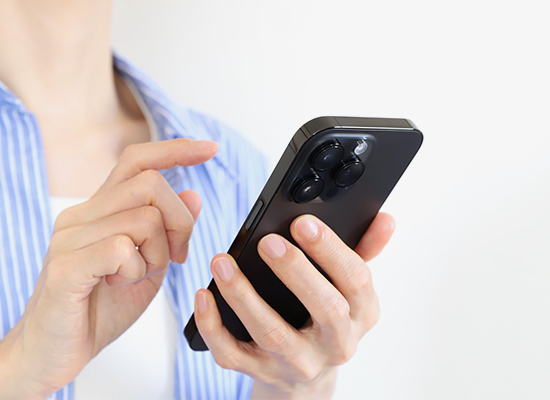スマホを操作してWEB予約している女性